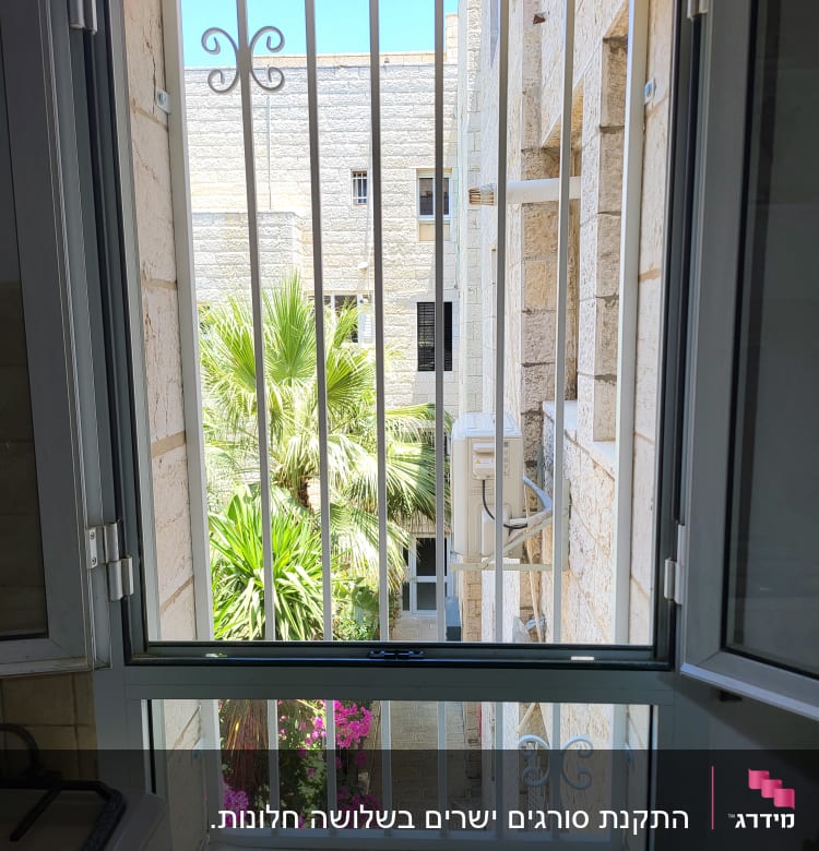 חלון עם סורגים לבנים ומסגרת מתכת